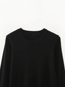 Close-up of the black crew neck long sleeve knitted shirt showing smooth fabric texture