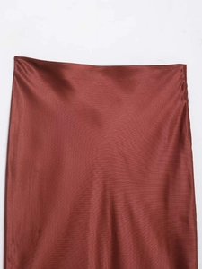Vue détaillée d'une jupe en satin rouge rouille avec coutures à la taille et texture