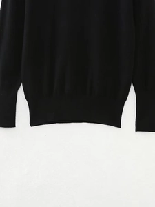 Detail shot of smooth ribbed cuffs and hem on this black long sleeve knit sweater