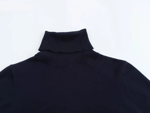 Detail of high turtleneck knit sweater with premium ribbed finish in navy blue