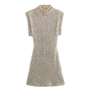Macro detail of champagne sequin dress featuring structured shoulders and high neckline