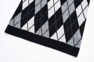 Detalle del patrón de rombos y dobladillo acanalado en un vestido sin mangas con cuello V