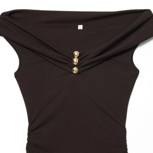 Chic black off-shoulder maxi dress with gold bead accents and elegant side ruching