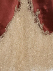 Gros plan détaillé du tissu en satin rouge foncé avec dentelle dorée brodée élégante