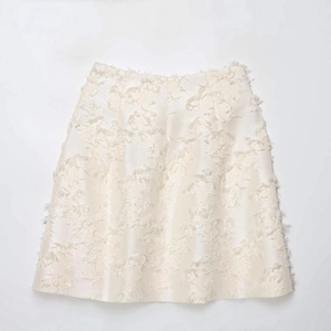 Elegant cream white A-line midi skirt featuring a textured 3D floral jacquard fabric design