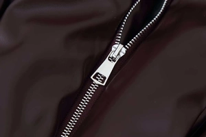Close-up of premium dark brown leather jacket with metallic silver zipper and logo detail