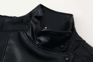 Close-up of litchi grain leather jacket collar with metallic snap button and zipper