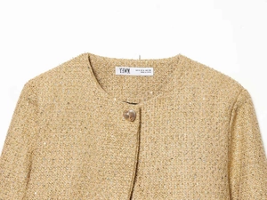 Close-up of tweed jacket neckline with sequins and embossed gold button detail