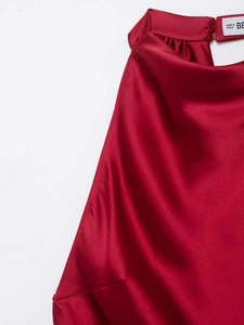 Detail of elegant satin halter neck with delicate pleats and button closure in dark red