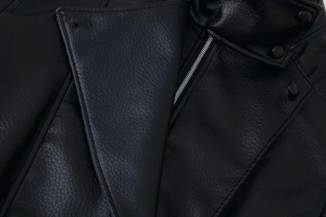 Close-up of litchi textured black leather jacket with silver zipper and stand collar