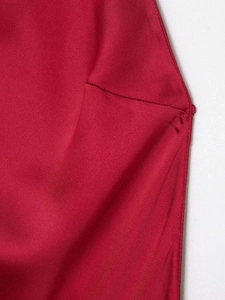 Detail of red satin dress showing smooth fabric texture and professional stitching finish