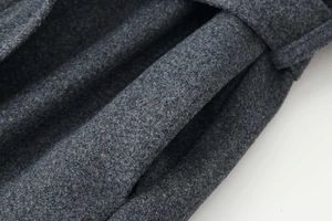Dettaglio macro del tessuto in lana grigio scuro e cucitura della tasca sul cappotto invernale