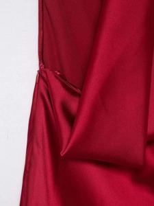 Detail view of high-quality dark red satin fabric showing a hidden side zipper closure