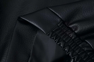 Macro detail of high-quality black lychee texture faux leather with neat stitching and lining