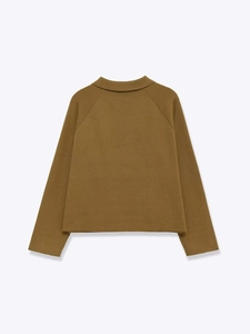 Détail du dos d'un cardigan en maille ocre avec col à revers et manches raglan élégantes