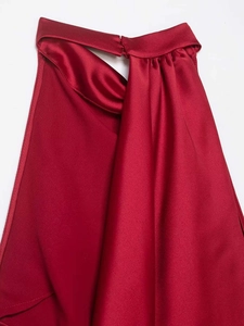 Detail of red satin halter neck dress showing elegant pleated collar and silky texture