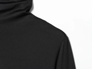 Detailed close-up of the black knit dress showing turtleneck collar and shoulder seams
