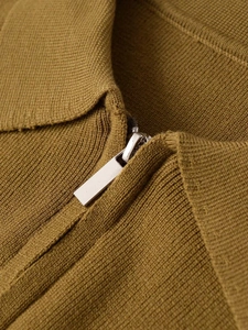 Gros plan d'un cardigan en maille marron avec détail de fermeture éclair en métal argenté
