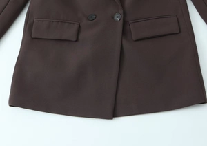 Detail view of coffee brown blazer featuring resin buttons and classic flap pockets