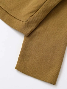 Détail macro du tricot jaune moutarde avec poignets côtelés sur le cardigan doux