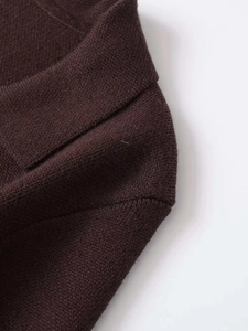 Detailed close-up of dark chocolate knit fabric and seamless collar stitching