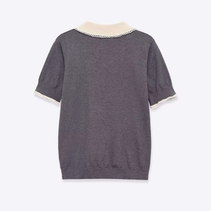Detail of the knit texture and wavy scallop lace edges on the grey short-sleeved sweater