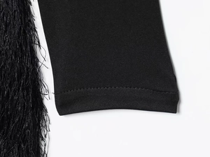 Detail of sleeve cuff featuring high-quality black tassels and knit fabric stitching