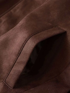 Close-up of side pocket on dark brown suede jacket showing clean stitching detail
