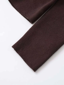 Detail shot of a dark brown knitted sweater cuff showing fine plain knit texture