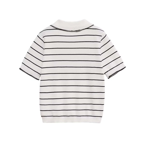Detail of white knit polo top with black stripes and delicate lace trim on collar and sleeves