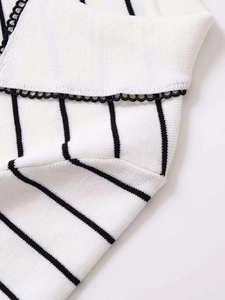 Macro shot of striped knit top featuring delicate black scalloped lace trim details