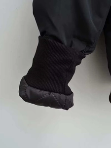 Detail der Rippbündchen und des gesteppten Innenfutters dieser schwarzen Bomberjacke