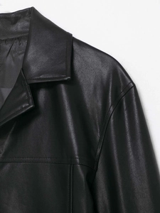 Detailed view of the black PU leather jacket's notch lapel and fine shoulder stitching