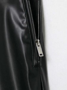 Detail shot of a silver metal zipper on black faux leather flared pants fabric texture