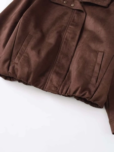 Detail of dark brown faux suede jacket featuring metal snaps and elastic hem