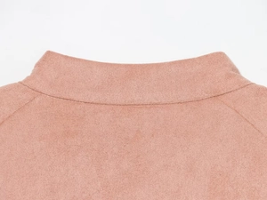Detailed macro view of soft pink faux suede fabric texture and neat stitching details