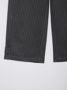 Detailaufnahme der Nadelstreifenhose in Grau mit dekorativem Riemen am Saum