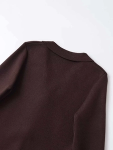 Detail of deep brown knit cardigan showing fine texture and collar craftsmanship