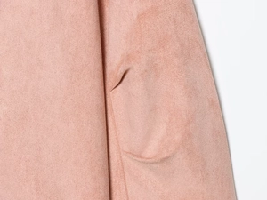 Macro shot of minimalist pink faux suede fabric with seamless pocket stitching detail