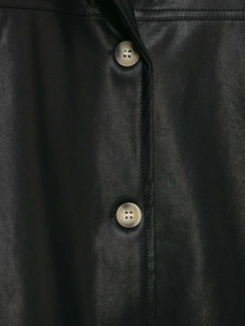 Close-up of black PU leather texture with tortoiseshell buttons and stitch detail