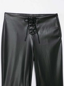 Detailed close-up of the front lace-up waist design on matte black faux leather trousers