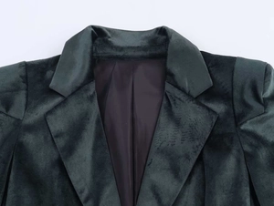 Détail du revers et de la doublure en soie noire sur un blazer en velours vert foncé