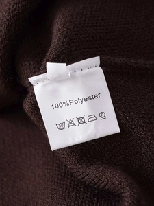 Close-up of the care label and 100% polyester fabric texture on a dark brown knit cardigan