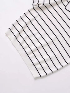 Close-up of white knitted top featuring black horizontal stripes and delicate lace trim