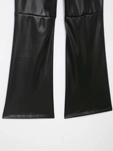 Detail of black faux leather flared trousers showing knee seam and smooth texture
