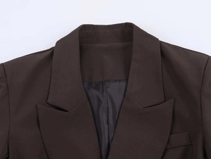 Close-up of deep brown peak lapel blazer with precision stitching and satin lining details