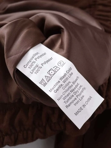 Detailed care label showing 100% polyester composition and washing instructions for jacket