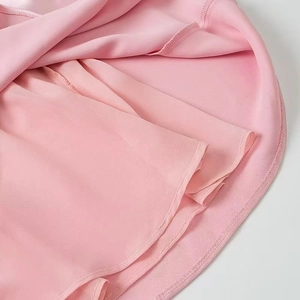 Detail of pink satin midi dress hem featuring double-layered fabric and fine edge stitching