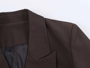 Detail of notch lapel and fabric texture on a coffee brown double-breasted blazer