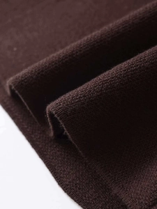 Close-up of chocolate brown knit fabric showing soft texture and premium jewelry buttons